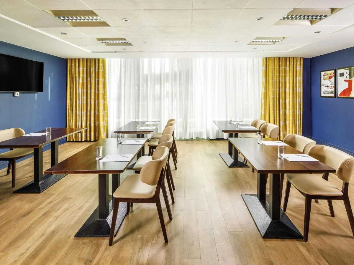 a conference room with tables and chairs and a flat screen tv at ibis Styles Birmingham Centre in Birmingham