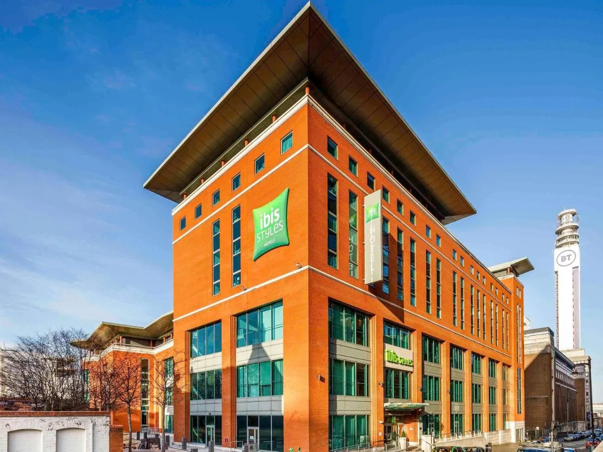 a large orange building with a clock tower in the background at ibis Styles Birmingham Centre in Birmingham